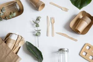 Composition with disposable paper and reusable tableware with natural leaves top view. Composition with disposable paper and reusable tableware with natural leaves top view.