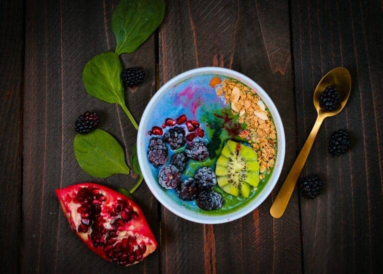 A Food Bowl With Pomegranate And Blackberries