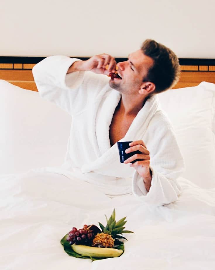 A Man In Bed Enjoying A Pineapple